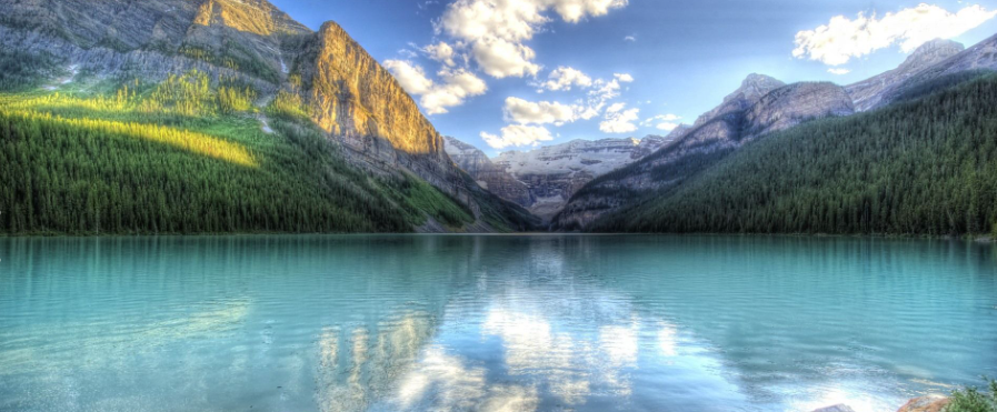 Auf dem Foto  eine Landschaft mit See, Wiese und grünen Bäumen zu sehen